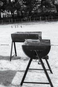 a grill sitting on a stand in a field at Festival Glamping At The Drum - Glamping Village in Edinburgh