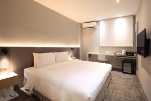 a hotel room with a large white bed in it at Cityinn Hotel Taipei Station Branch I in Taipei +40 photos