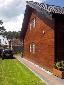 a wooden house with a black roof at Apartamenty Kompas in Międzywodzie