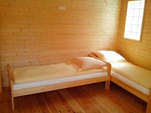 ミエンジボジェにあるApartamenty Kompasのログキャビン内のベッド2台が備わる部屋です。