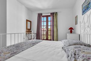 a white bedroom with a bed and a window at Authentic Hideaway by Riva with Free Parking in Podgora