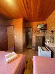 a room with two beds and a kitchen with a sink at Aconchego do céu in Conceição da Ibitipoca +19 photos