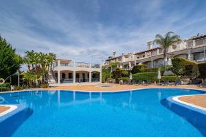 a large blue swimming pool in front of a building at Townhouse Sasha in Almancil