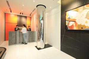 a lobby with two people standing at a counter at Cityinn Hotel Taipei Station Branch I in Taipei