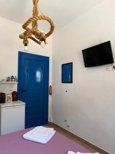 a room with a blue door and a tv at Aegean Dream Room in Kamares
