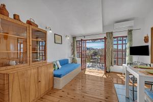 a living room with a blue couch and a television at Authentic Hideaway by Riva with Free Parking in Podgora