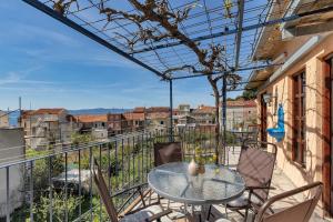 a patio with a table and chairs on a balcony at Authentic Hideaway by Riva with Free Parking in Podgora