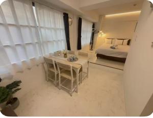 a bedroom with a bed and a table in a room at Lucky民泊 in Osaka