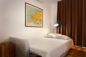 ein Schlafzimmer mit einem Bett mit einer Karte an der Wand in der Unterkunft Fabrica Apart in Porto