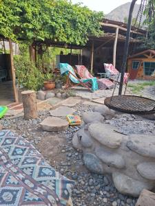 a garden with chairs and rocks and a house at Ecoalbergue Retablos Perú Habitación YING YANG in Lunahuaná