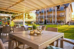 a table and chairs on a patio in front of a building at Pensjonat Marynarski - Apartamenty in Darlowko