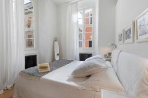 a white bedroom with a large bed and windows at C123 Luxury in Chiavari