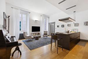 a living room with a kitchen and a living room with a piano at C123 Luxury in Chiavari