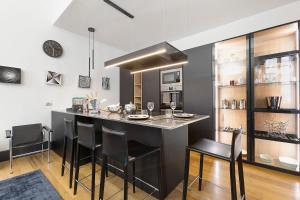 a kitchen with a bar with black stools at C123 Luxury in Chiavari