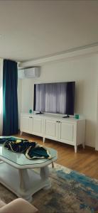 a living room with a table and a large television at Apartman Trg 892 in Livno