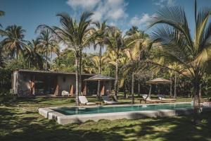 a resort with a swimming pool and palm trees at ICACO refugio de playa in Guachaca