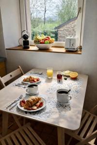 a table with two plates of food on it at AppartCosy 27 Epine in Châteaubourg