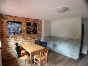 a dining room with a wooden table and chairs at Chata Florian in Adolfov