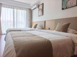 a hotel room with three beds in front of a window at Hotel Kyson 凯森酒店 in Cocody