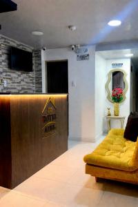 eine Lobby mit einer gelben Couch in einem Zimmer in der Unterkunft Hotel Adel in Manizales