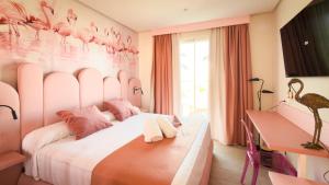 a bedroom with a bed with pink flamingos on the wall at On Pink Motel in Matalascañas