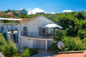 a white house with a deck and an umbrella at Ferienhaus Sun & Sea in Utjeha