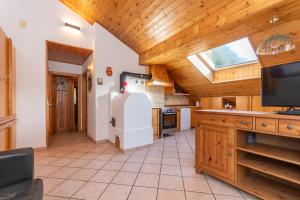 a kitchen with a refrigerator and a wooden ceiling at Ciasa Gaia in Mazzin