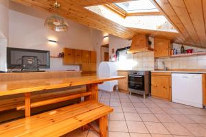 a kitchen with wooden cabinets and a wooden table at Ciasa Gaia in Mazzin +24 photos