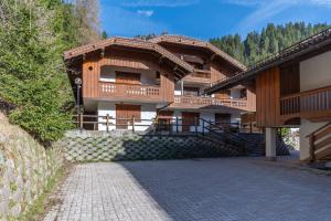 a large wooden building with a staircase in front of it at Ciasa Gaia in Mazzin