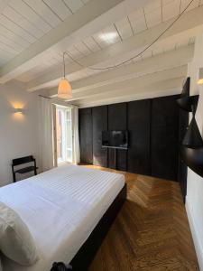 a bedroom with a bed and a tv on the wall at Il Cantun in Monforte dʼAlba +12 photos