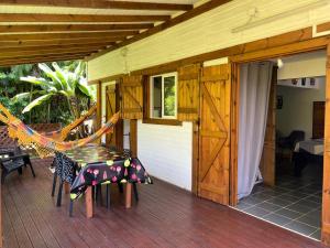 a porch with a hammock on a house at Coconut Studio in Capesterre-Belle-Eau