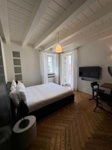 a bedroom with a large bed and a television at Il Cantun in Monforte dʼAlba