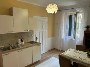a kitchen with white cabinets and a table and a window at Apartment Bačvice in Split