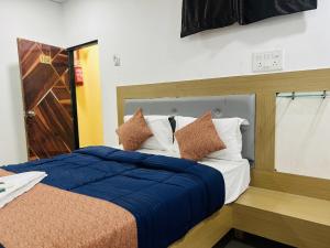 a bedroom with two beds with blue blankets and pillows at Jazz residency hotel in Mumbai