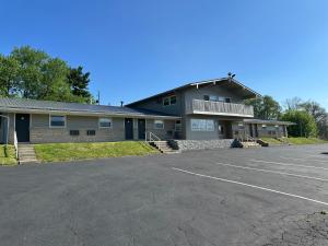 a building with a parking lot in front of it at Budget Inn - Cambridge in Fairdale