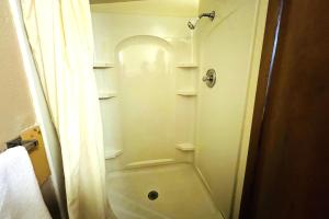 a small bathroom with a shower and a toilet at Sparta Motel Near St Louis- Mississippi River IL in Sparta +15 photos