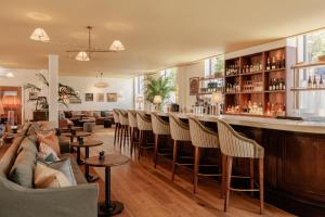 a bar in a living room with a bunch of chairs at Wilde Cambridge City Centre in Cambridge