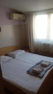 a bed with two towels on it with a window at Hostel Mlin Balkan in Skopje