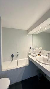 a bathroom with a tub and a sink and a mirror at Colosseo Deluxe YH in Rome +36 photos