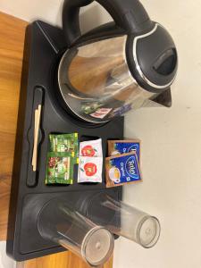 a black table with a tea kettle and food on it at Aps inn munnar in Munnar