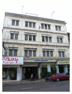 a large building with a red car parked in front of it at โรงแรมวัฒนาตรัง in Trang