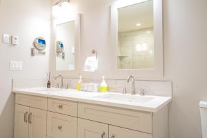 a white bathroom with a sink and a mirror at White Spruce Condo by Canadian Rockies Vacation Rentals in Canmore +35 photos