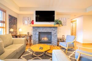 a living room with a couch and a fireplace at White Spruce Condo by Canadian Rockies Vacation Rentals in Canmore