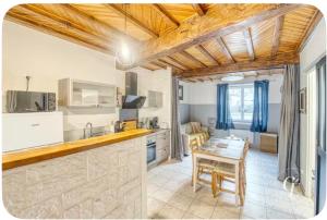 a kitchen and dining room with a table and a dining room at les Renardeaux maison cosy idéal PRO CNPE PIPA et Familles in Ambutrix