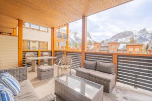 a balcony with a table and chairs and mountains at White Spruce Condo by Canadian Rockies Vacation Rentals in Canmore