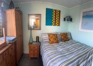 a bedroom with a bed with a dresser and a mirror at Bridlington's Bolt Hole chalet in Bridlington