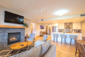 a living room with a couch and a fireplace at White Spruce Condo by Canadian Rockies Vacation Rentals in Canmore