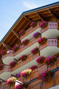 a building with flower boxes on the side of it at Chalet RoyAlp Hôtel & Spa in Villars-sur-Ollon