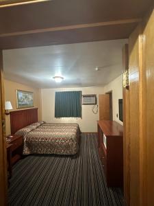a hotel room with a bed and a desk at Budget Inn - Cambridge in Fairdale +2 photos