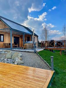 a cabin with a wooden deck in front of it at Somnium Pieniny in Tylka